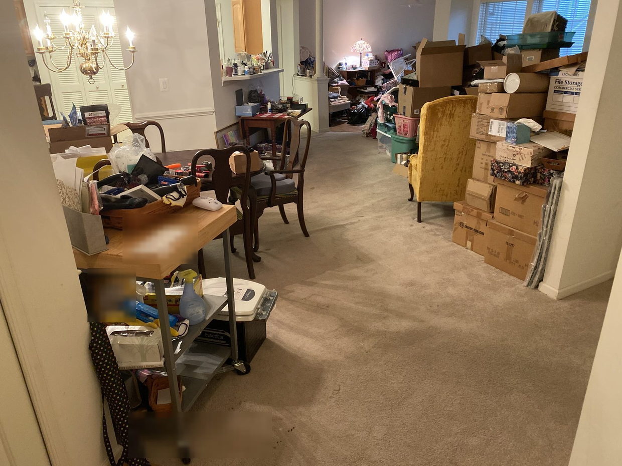 The same living and dining area partly cleared, floor visible, boxes stacked along one wall